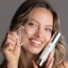 Uśmiechnięta modelka z NMF xpress cream i bryłą lodu przy twarzy