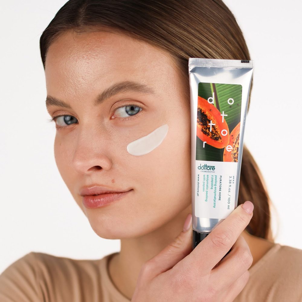 a woman holding a tube of cream