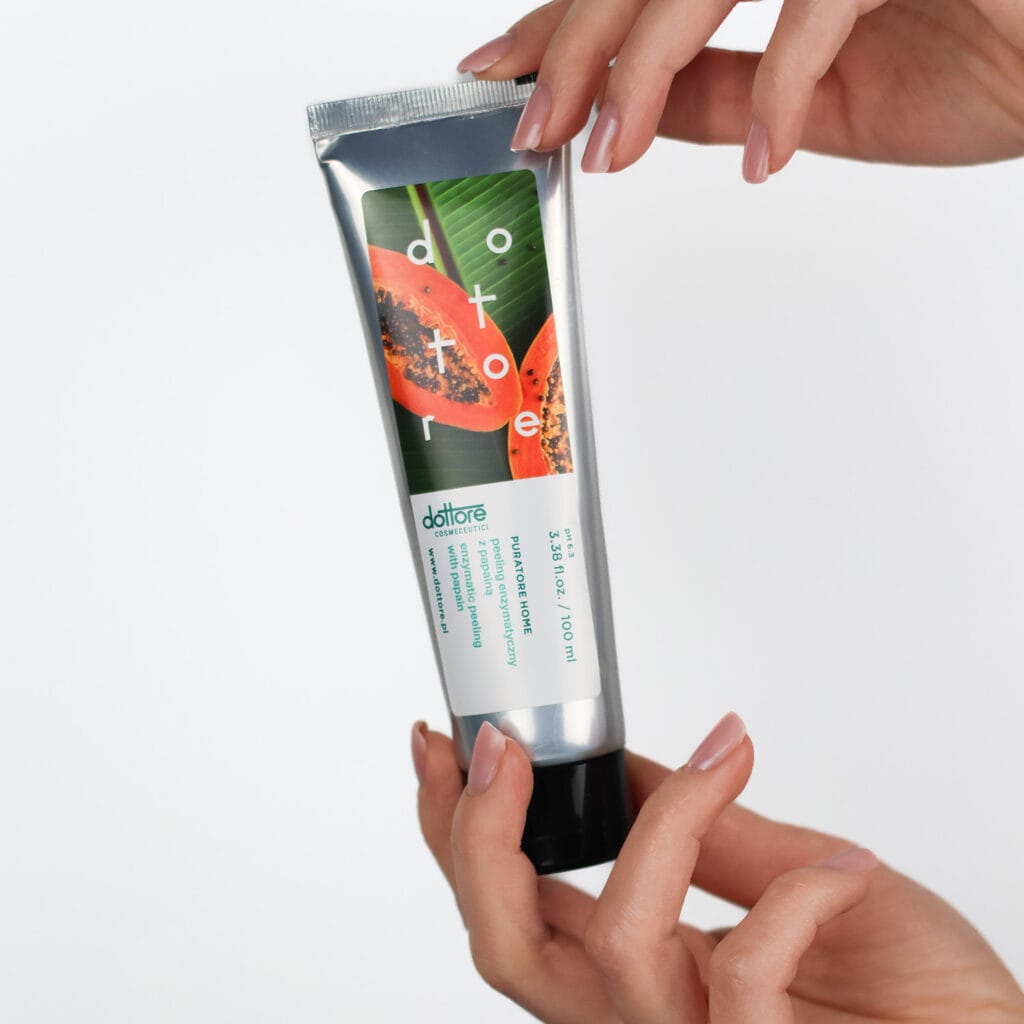 a person holding a tube of cream