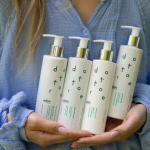 Kobieta trzymająca w dłoniach zestaw produktów do demakijażu i mycia twarzy z serii Sensitore.