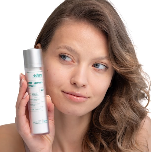 Uśmiechnięta kobieta trzymająca przy policzku silnie nawilżający krem NMF xpress.